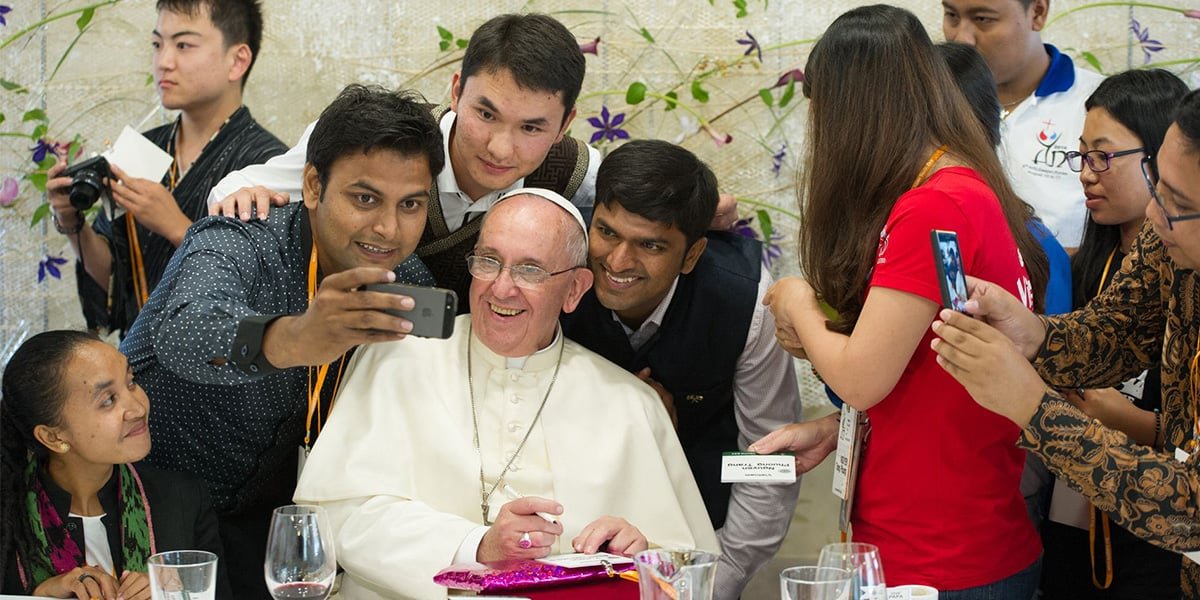 Pope Francis (C) poses for a selfie as he meets young people at the Major Seminar in Daejeon, on August 15, 2014. — AFP