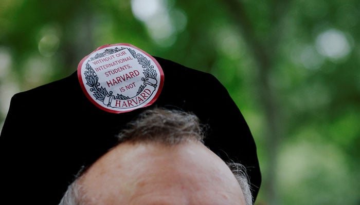 A member of the faculty wears a sticker reading Without Our International Students, Harvard Is Not Harvard during Harvard Universitys 374th Commencement Exercises in Cambridge, Massachusetts, US, May 29, 2025. — Reuters