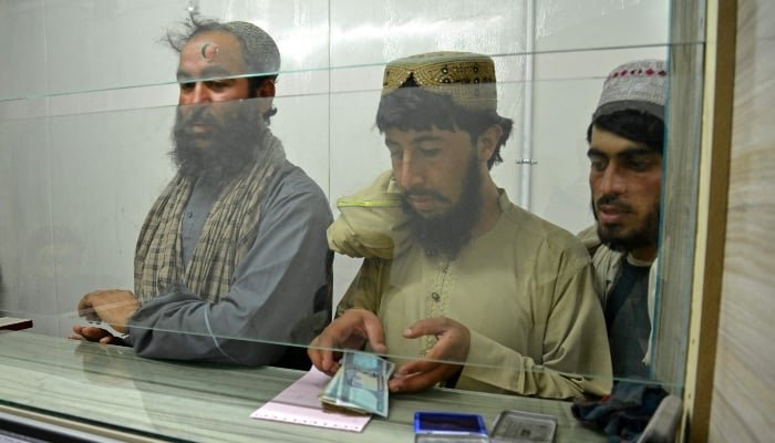 A Taliban government employee (C) receives his salary at the New Kabul Bank in Kandahar on June 2, 2025. — AFP