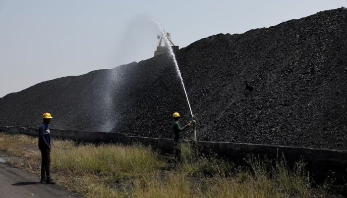 Employees perform cooling operations where coal is stored at the NTPC (National Thermal Power Corporation) power plant in Solapur, India, March 2, 2025. — Reuters