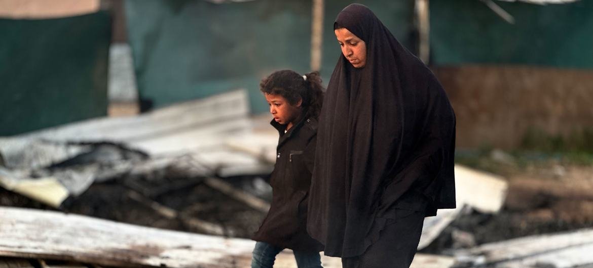 A woman and child walk through the rubble of Gaza. A woman and child walk through the rubble of Gaza.
