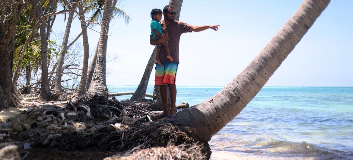A father and his daughter on a stretch of severely eroded beach in Dhiffushi island, in the Maldives. A father and his daughter on a stretch of severely eroded beach in Dhiffushi island, in the Maldives.