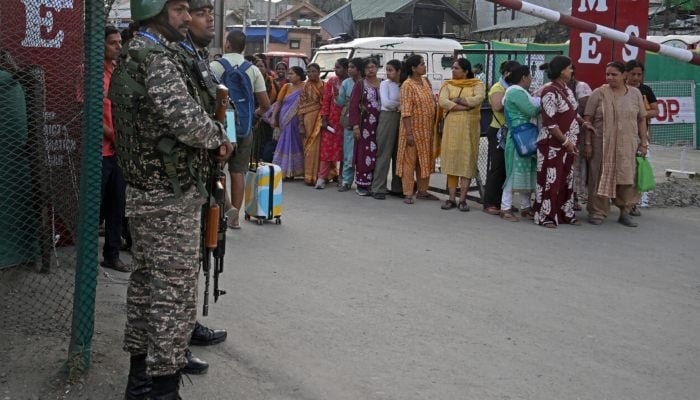 Indian security personnel stand guard as Hindu pilgrims await their registration ahead of the the annual Amarnath pilgrimage. — AFP